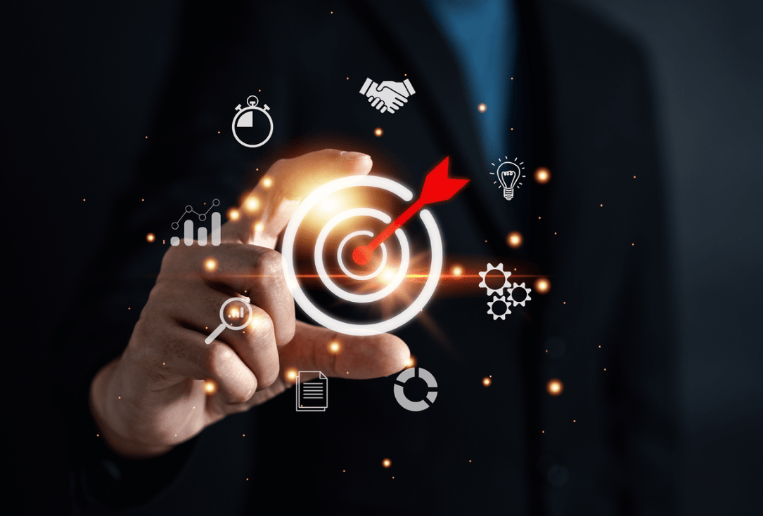 A hand points at a glowing bullseye target with a red arrow, surrounded by icons for analytics, timing, ideas, and teamwork.