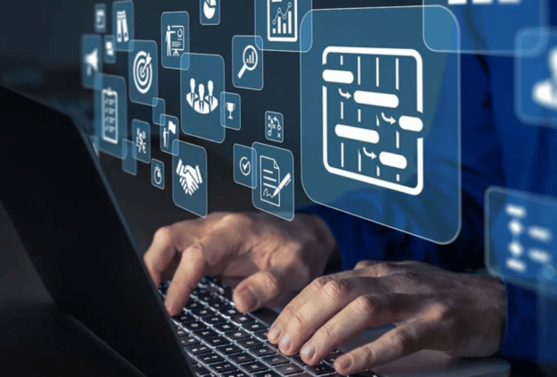 Hands typing on a laptop with blue holographic icons and flowcharts floating above.