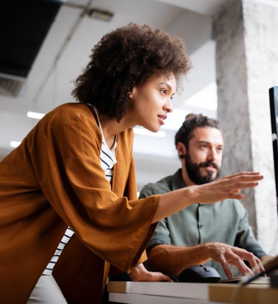 Woman standing and collaborating with a team at Talent Titan using an autonomous AI hiring agents platform for recruitment automation.